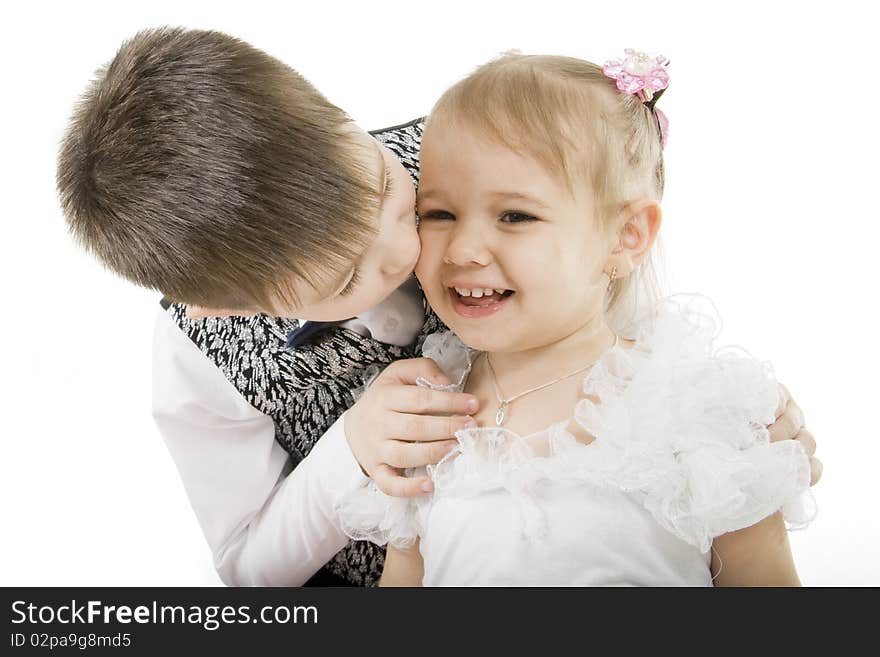 Small the boy kisses sister on a white background. Small the boy kisses sister on a white background