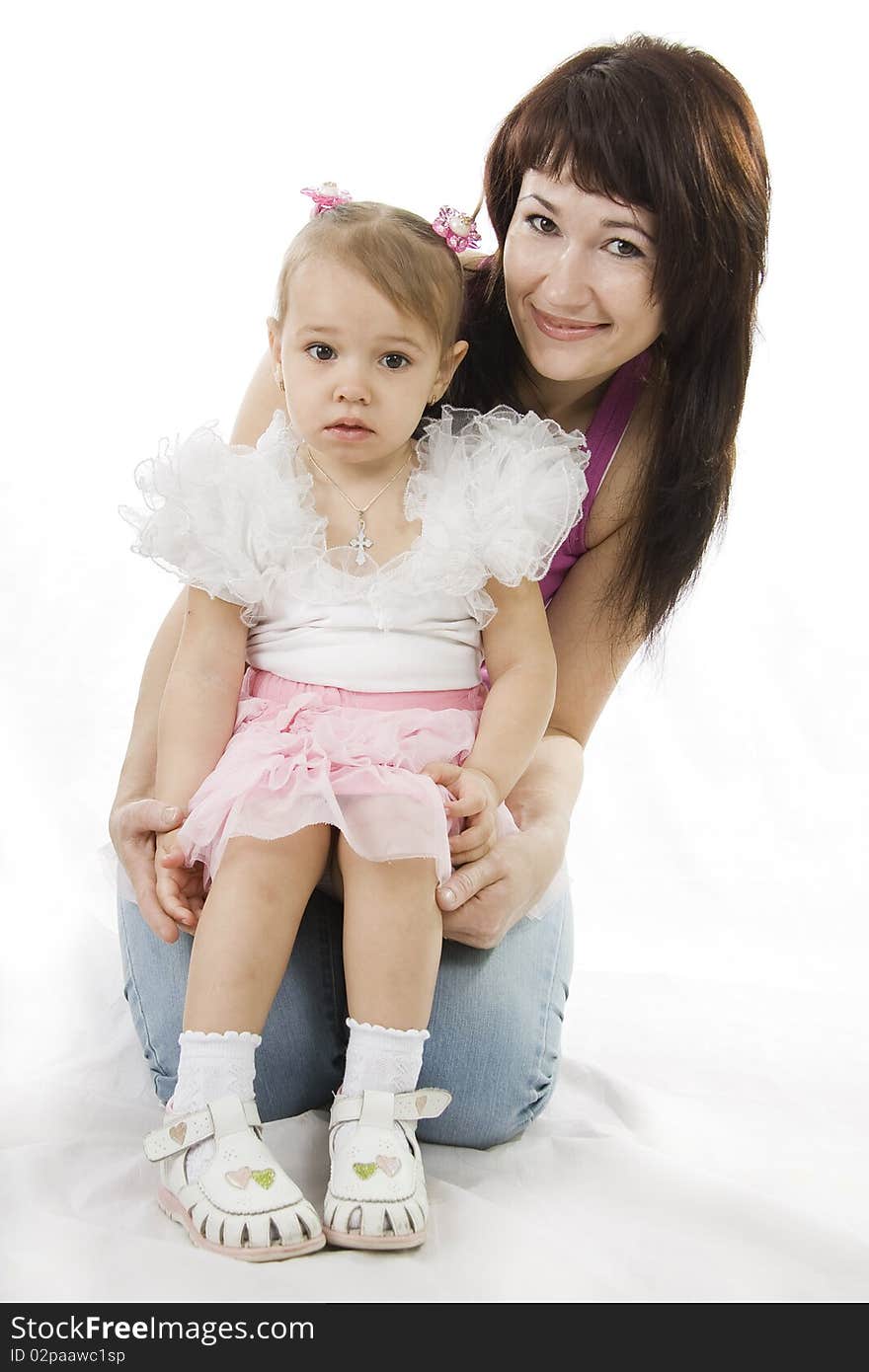 Young and beautiful mother with her sweet little daughter isolated on white. Young and beautiful mother with her sweet little daughter isolated on white.