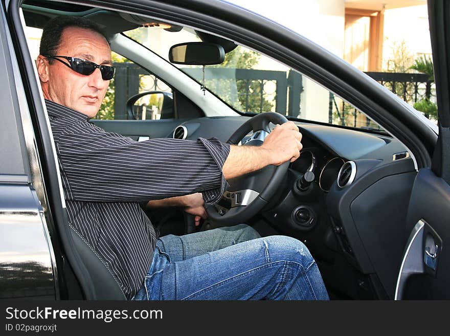 Man in new black car. Man in new black car.