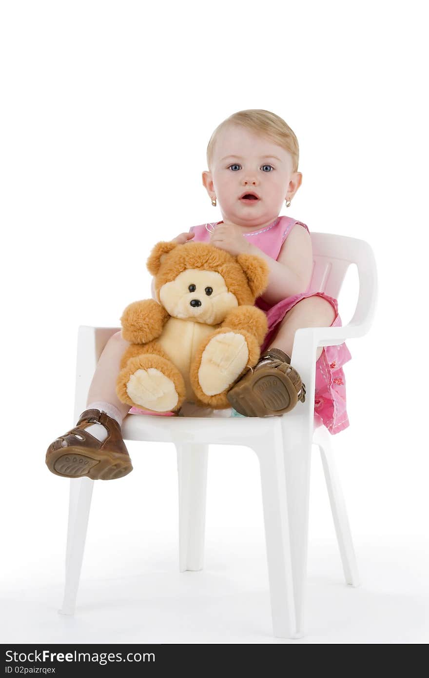 Toddler with his toy on stool on white background.