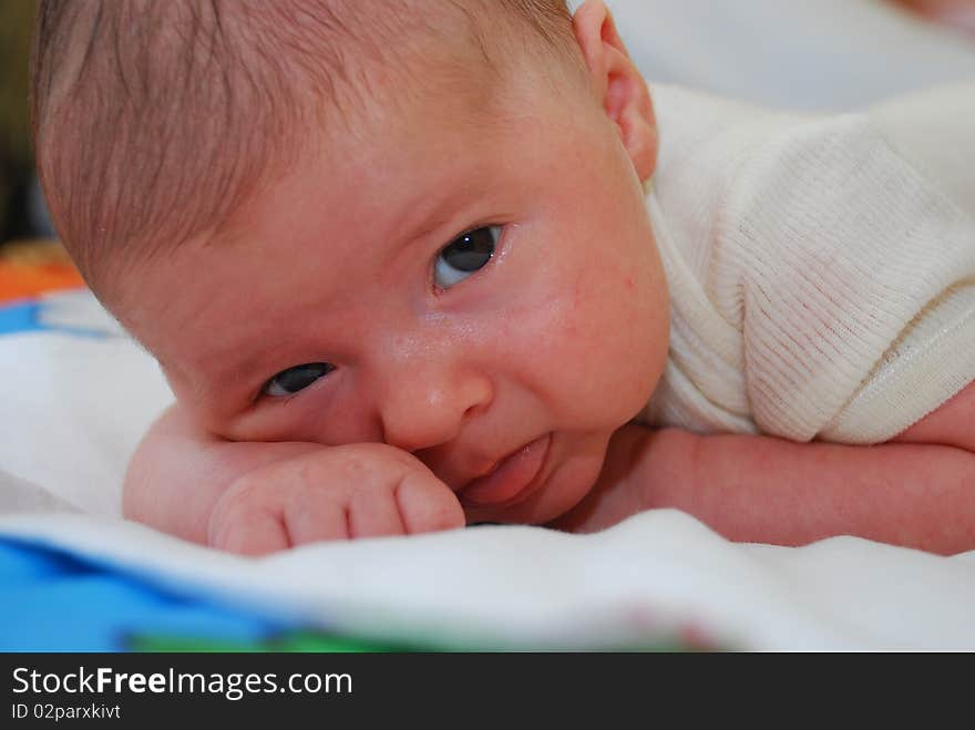 Little baby boy lying indoor on a bed. Little baby boy lying indoor on a bed