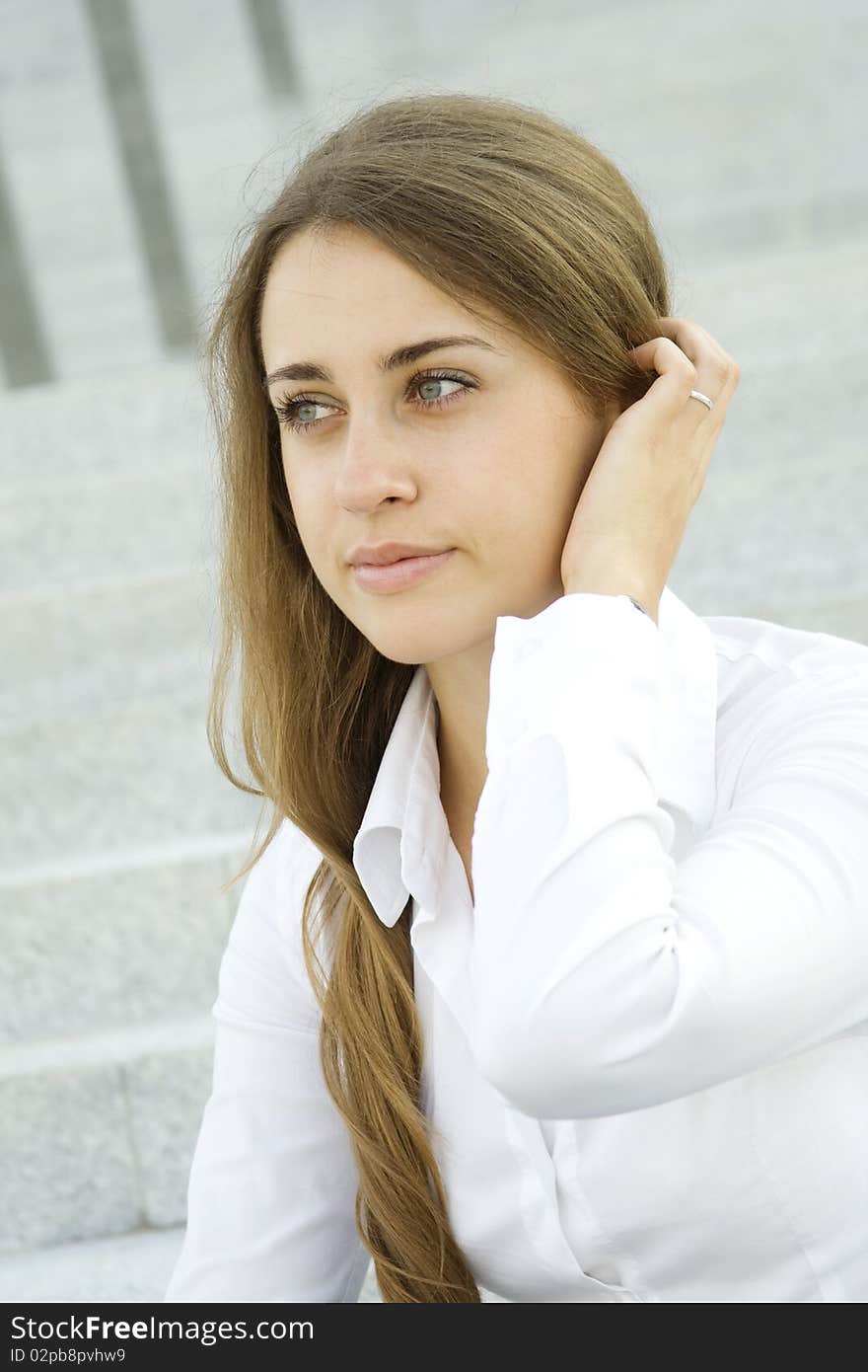 Portrait of a young specialist smiles on the background of the stairs and office space, and her hair / hairstyle. Portrait of a young specialist smiles on the background of the stairs and office space, and her hair / hairstyle