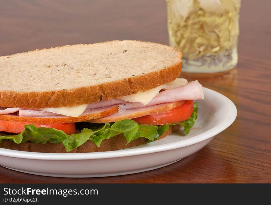 Ham and swiss cheese sandwich with lettuce and tomato on rye bread. Ham and swiss cheese sandwich with lettuce and tomato on rye bread