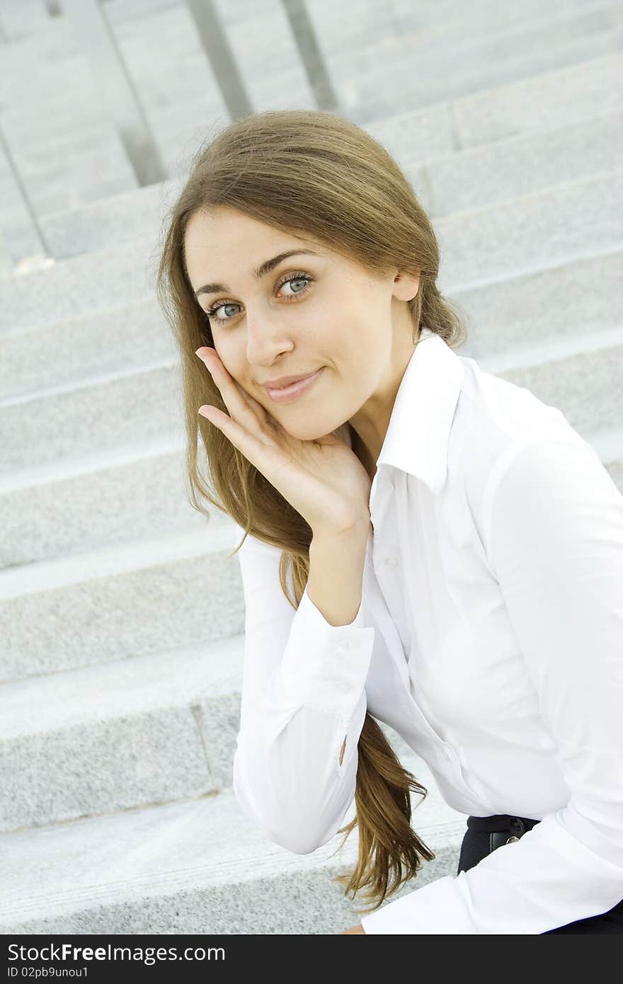 Portrait of a young specialist smiles on the background of the stairs and office space. Portrait of a young specialist smiles on the background of the stairs and office space