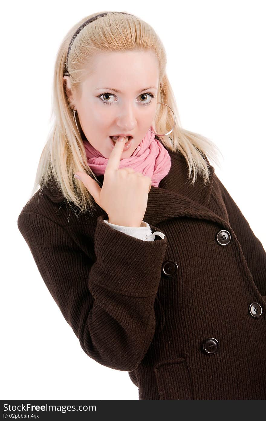 Portrait of a shy blond young girl in coat with finger in mouth