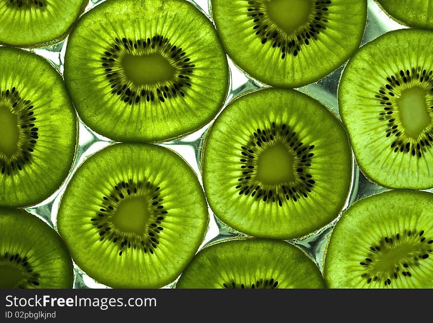 Sliced kiwi on the glass with flowing water. Sliced kiwi on the glass with flowing water