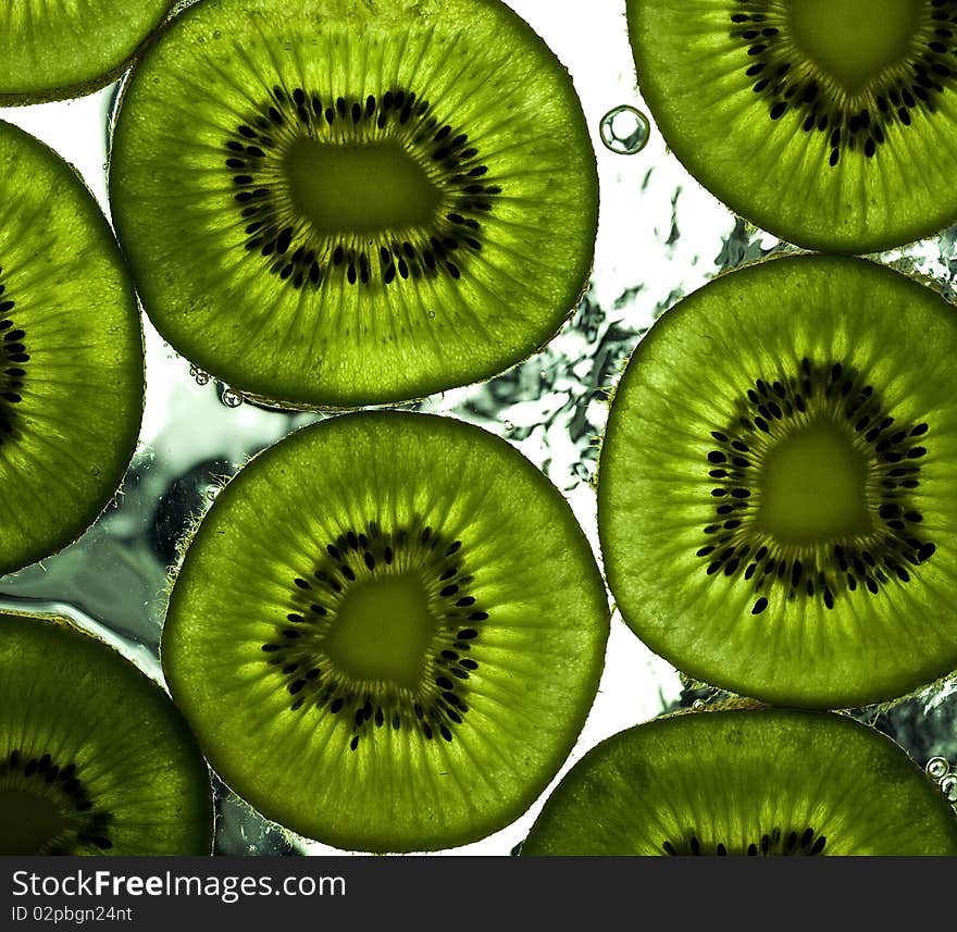 Sliced kiwi on the glass with flowing water. Sliced kiwi on the glass with flowing water