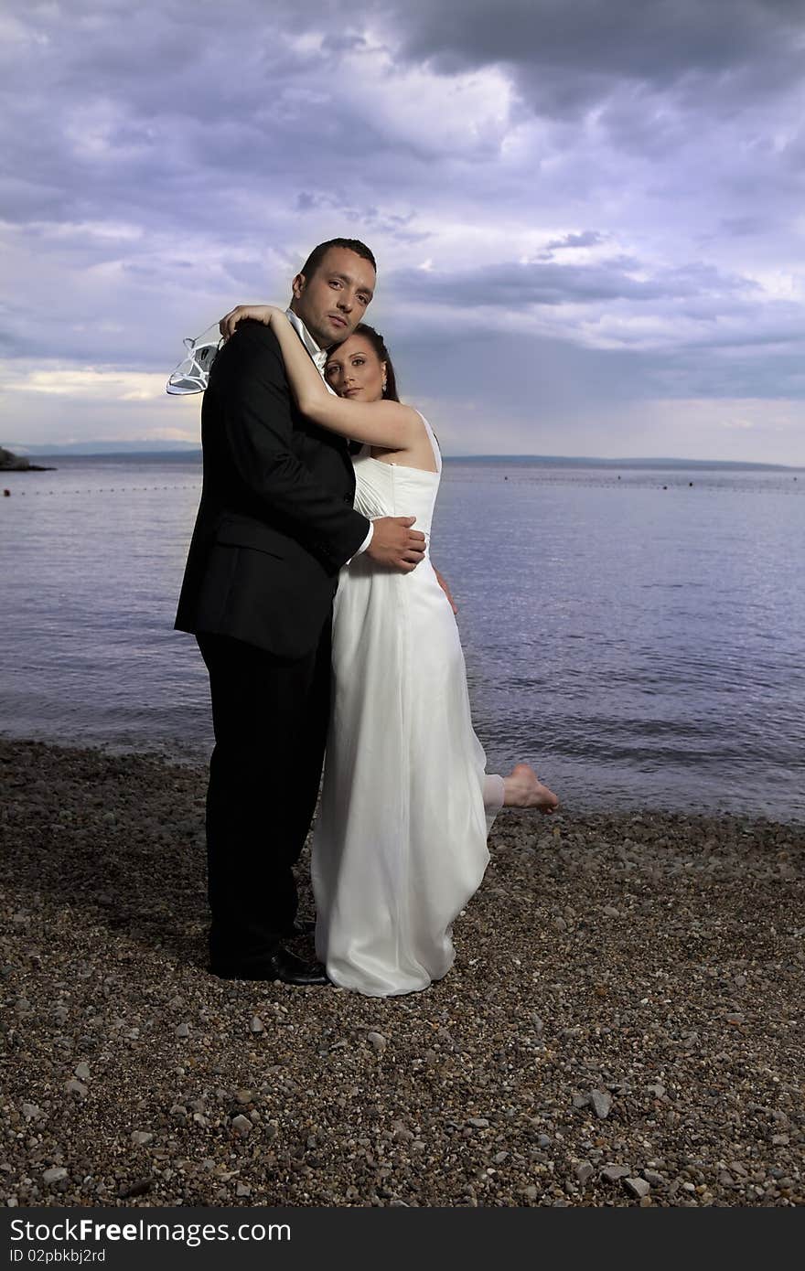 Wedding couple by the sea, dramatic sky