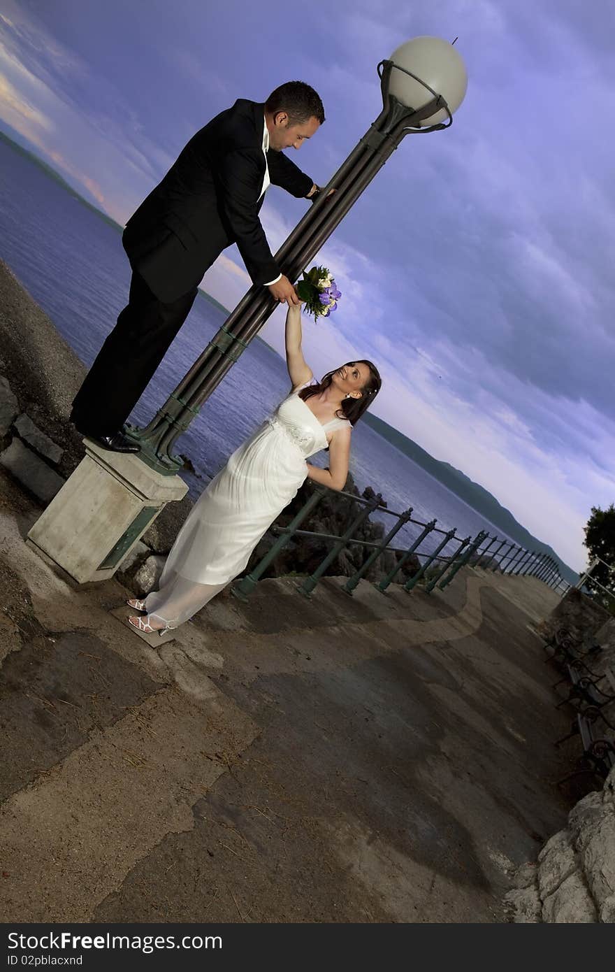 Wedding couple by the sea, dramatic sky