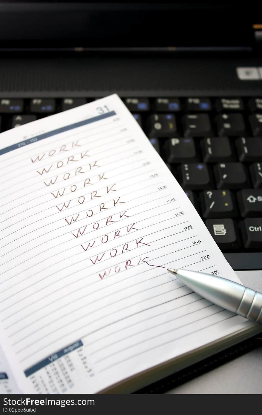 A notepad and a pen on top of a laptop