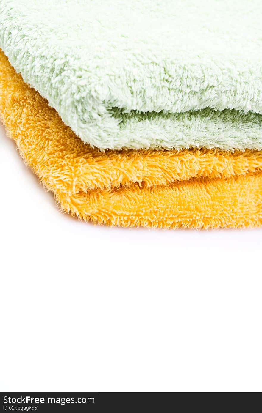 Orange and green folded towels isolated on white background