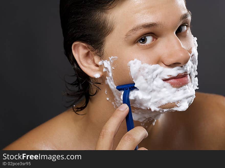 handsome young man shaving. handsome young man shaving