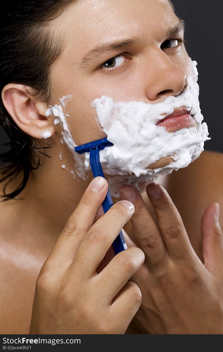 handsome young man shaving. handsome young man shaving