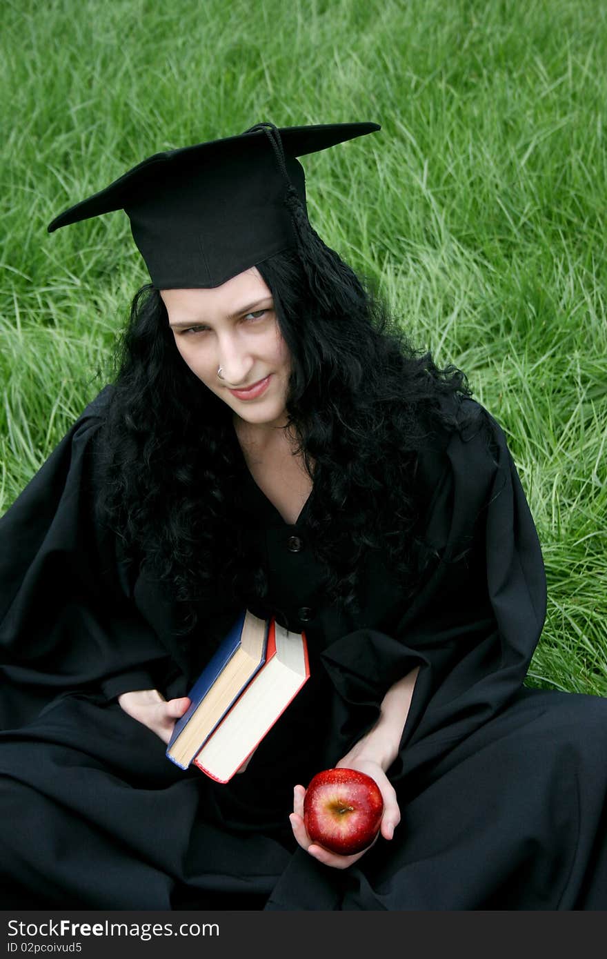 Caucasian student in gown with books