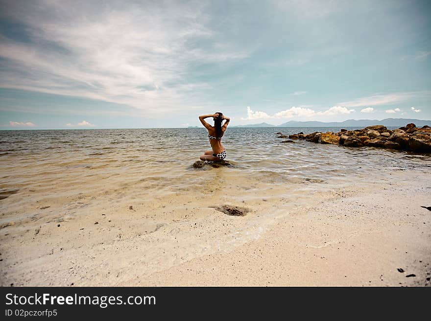 Woman siting on the ston in ocean. Woman siting on the ston in ocean...