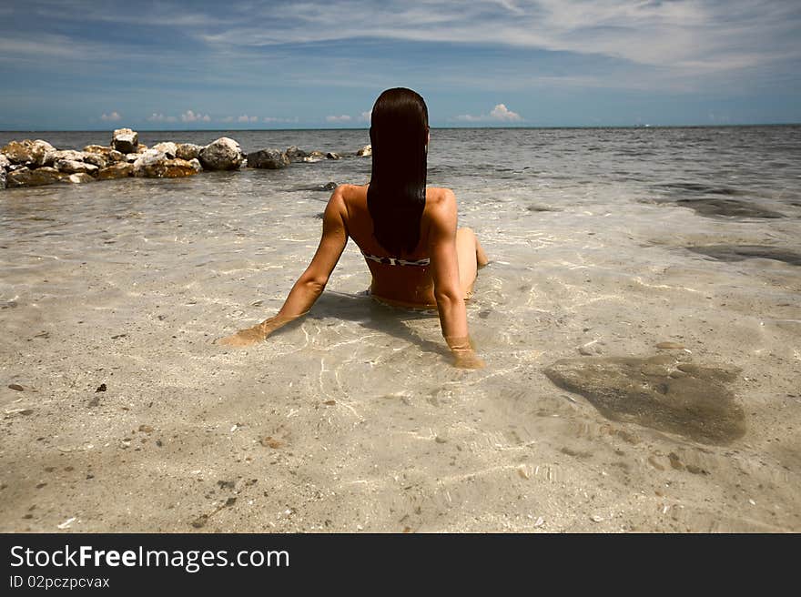 Woman in the ocean sitting in the water...