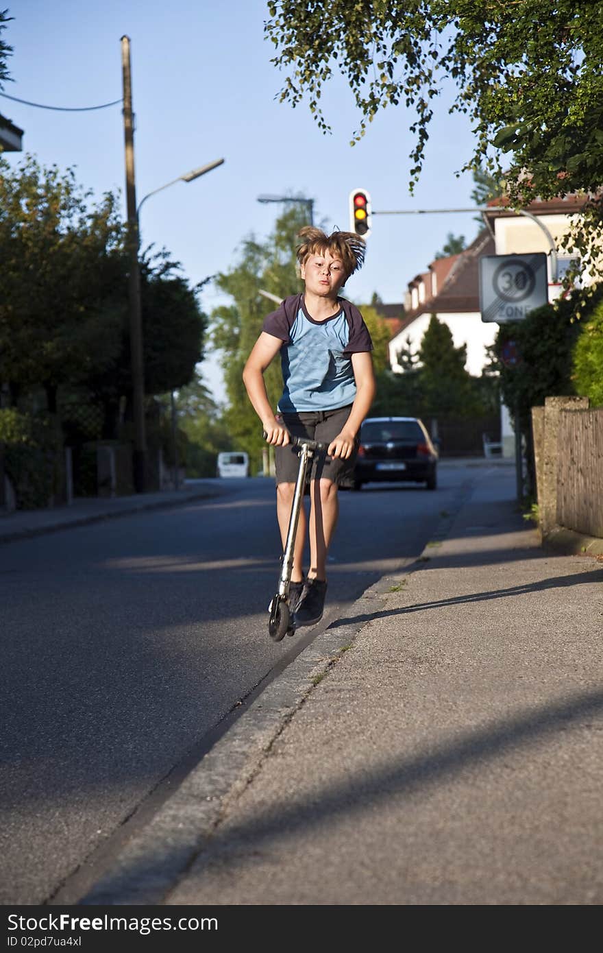 Boy With Scooter On The Street