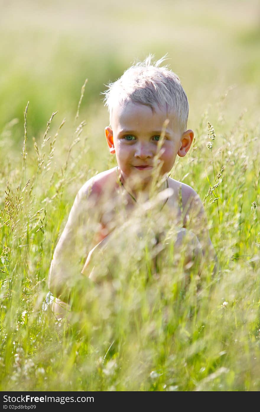 Wet Boy On The Field Among The Grass