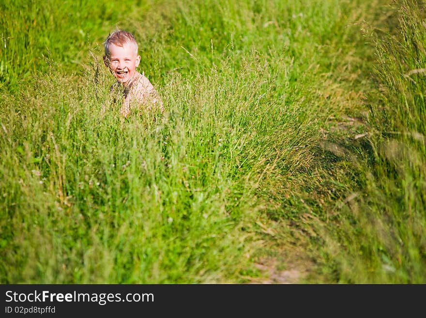 Laughing boy among the grass