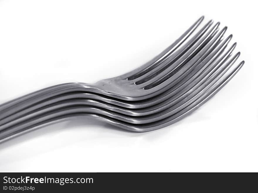 An image of 5 piled forks over a white background