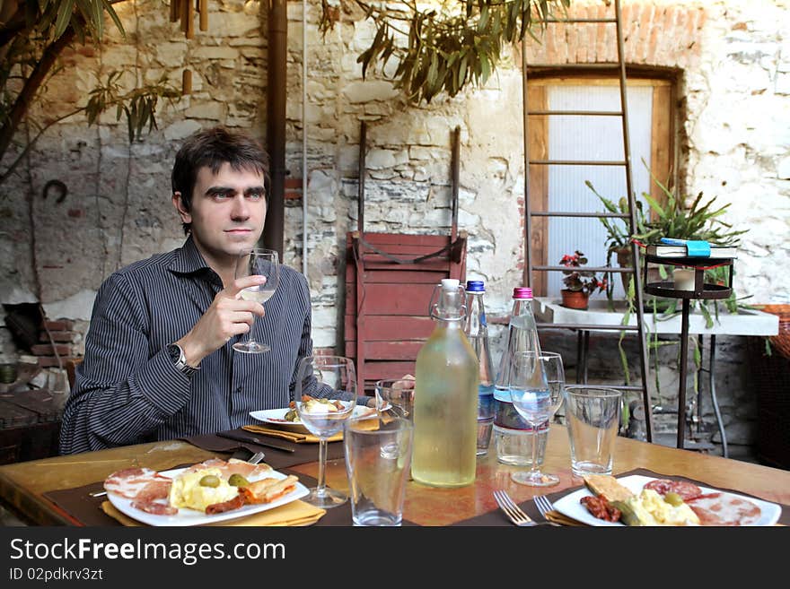 Young man drinking a glass of water at the table ready for dinner