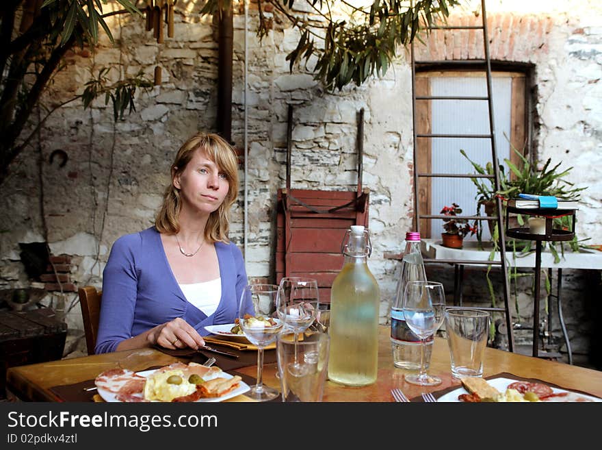 Woman sitting in a restaurant and having dinner