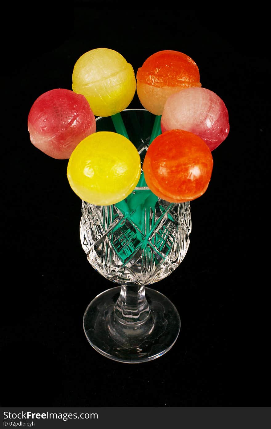 Colorful sweet lollipops in the glass on the black background