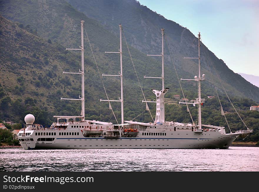 Cruise ship in a bay with mountains in background