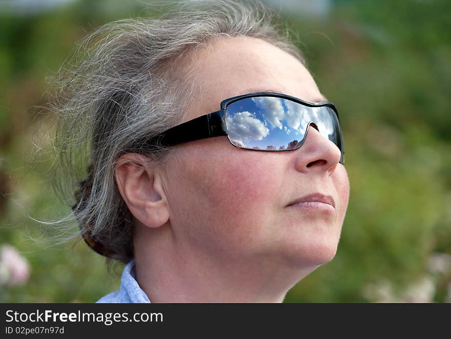 Mature Woman Looking Up To The Sky with Sunglasses