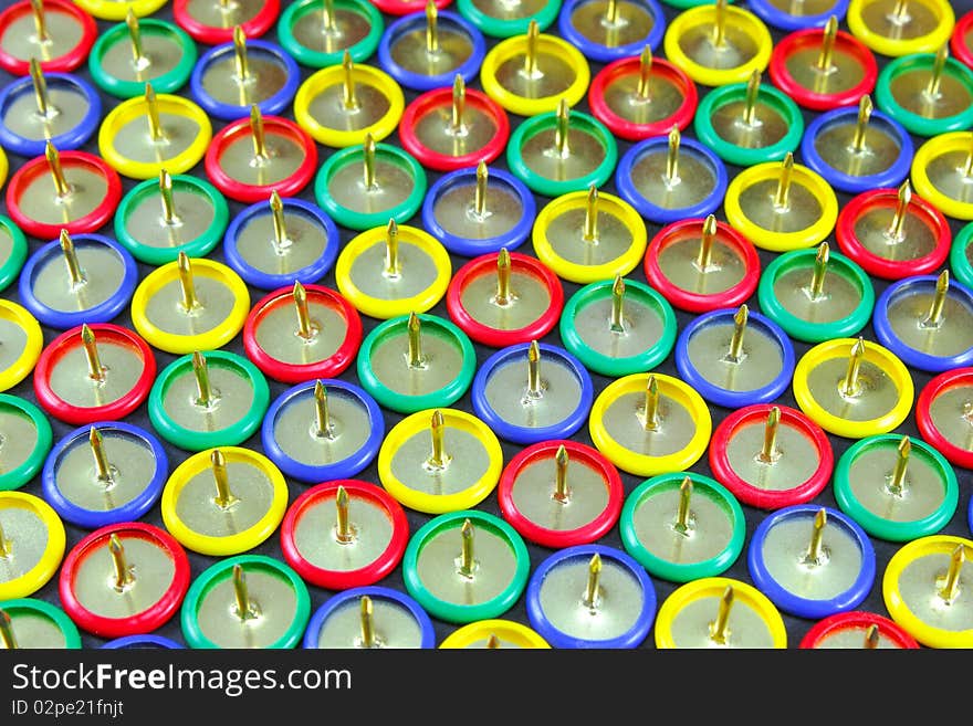 A group of colored drawing pins in formation