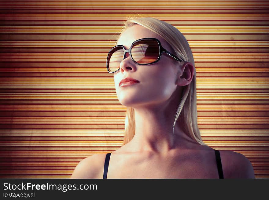 Beautiful woman wearing sunglasses with colouresd stripes on the background. Beautiful woman wearing sunglasses with colouresd stripes on the background