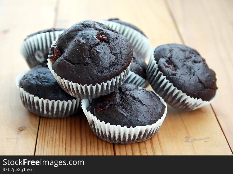 Delicious cocoa and banana muffins on a wooden table