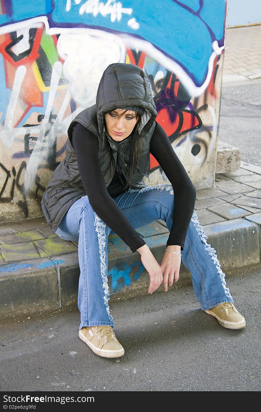 Girl sitting on sidewalk