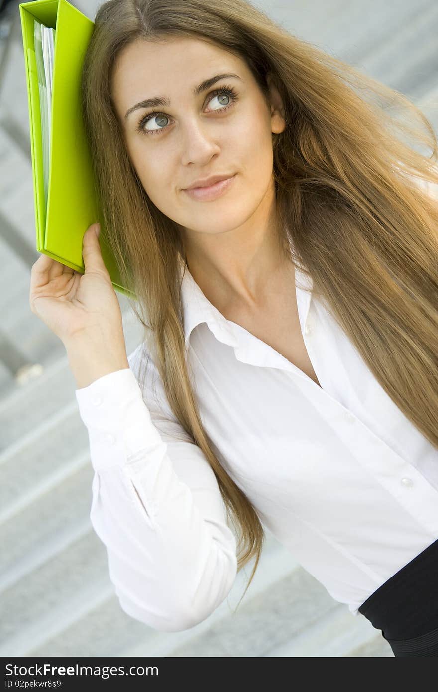 Attractive young businesswoman smiling with a green folder. Attractive young businesswoman smiling with a green folder.