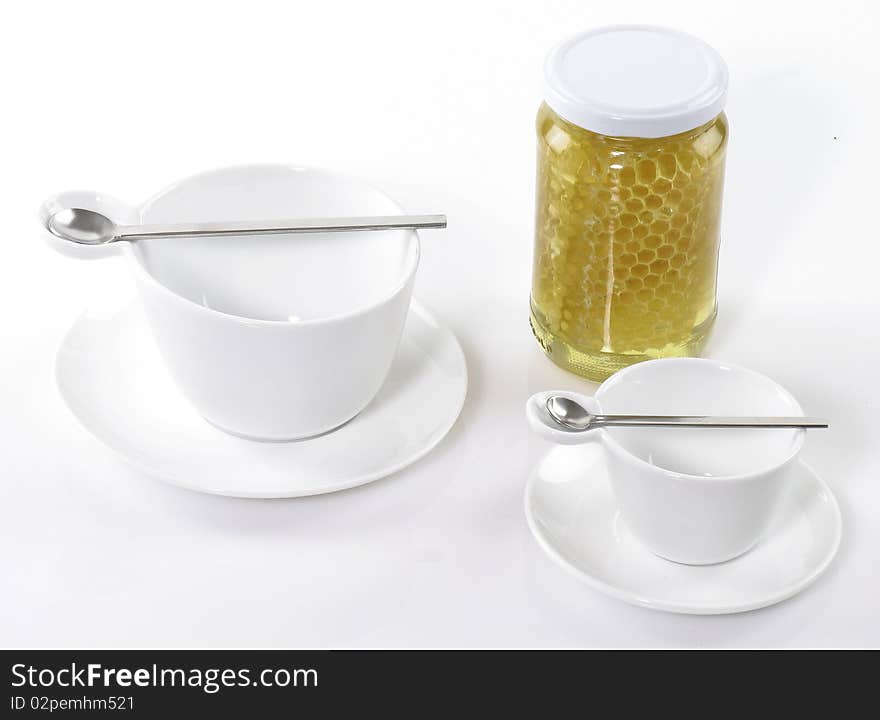 Tea cups and honey on white