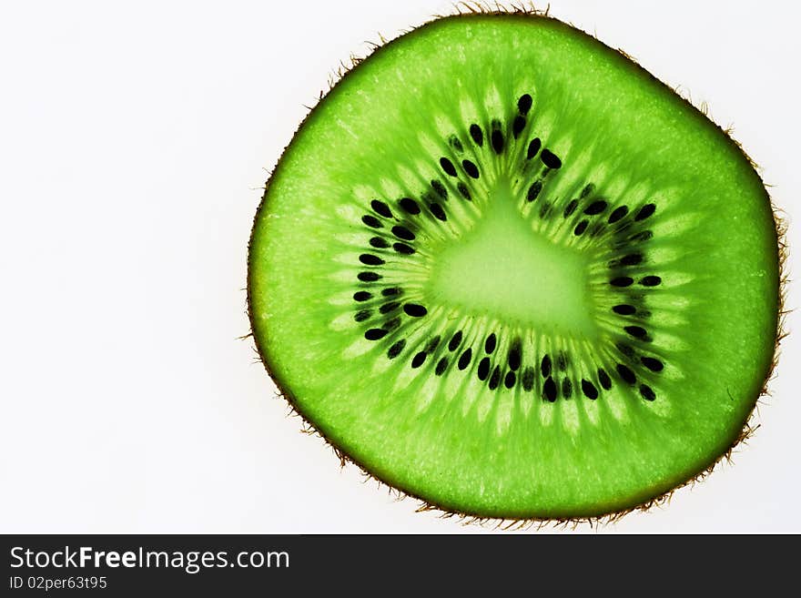 A bright green slice of kiwi with dark seeds and a prickly skin