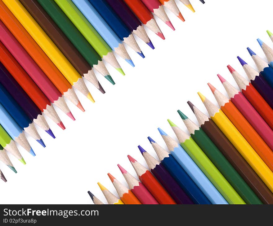 Colored pencils form a frame over a white background. Copy space. Colored pencils form a frame over a white background. Copy space.