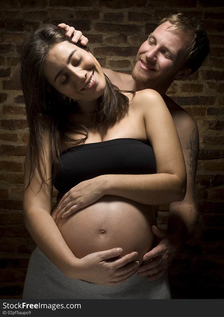 A man caressing his beauty pregnant wife. A man caressing his beauty pregnant wife.