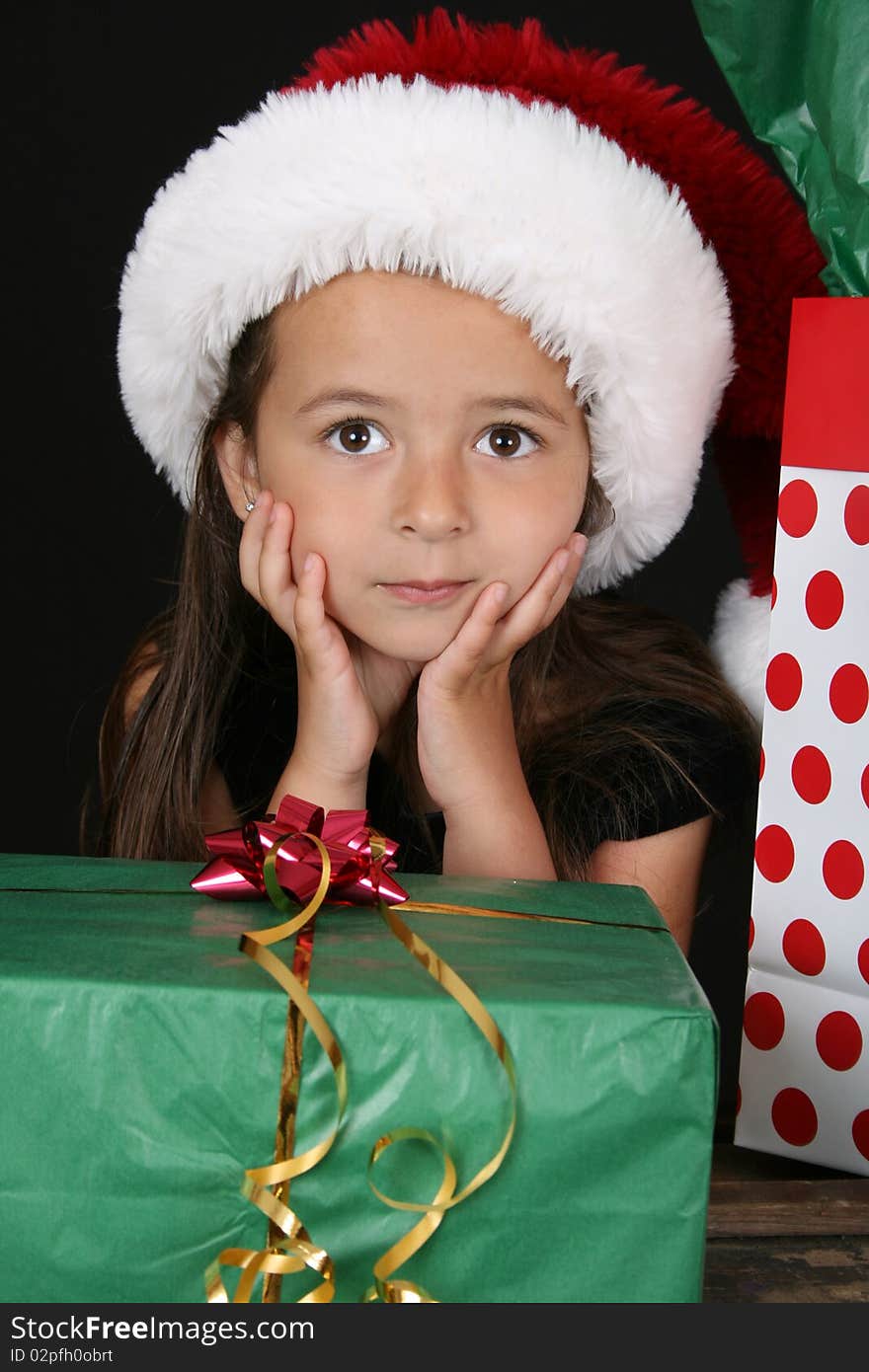 Cute brunette girl sitting amongst christmas gifts