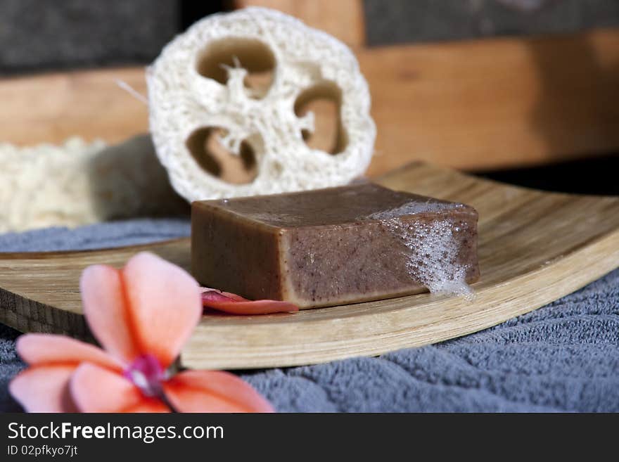 Organic soap with foam on bamboo soap plate with flower and towel