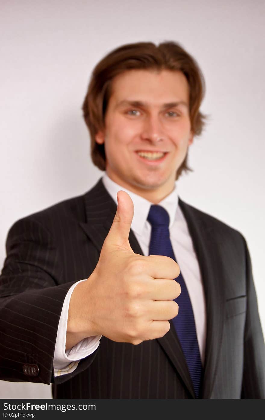 Young businessman showing thumb up. Young businessman showing thumb up