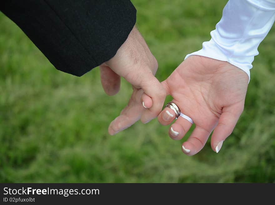 Close up of bride and groom joining hands and on to the road of life. Close up of bride and groom joining hands and on to the road of life.