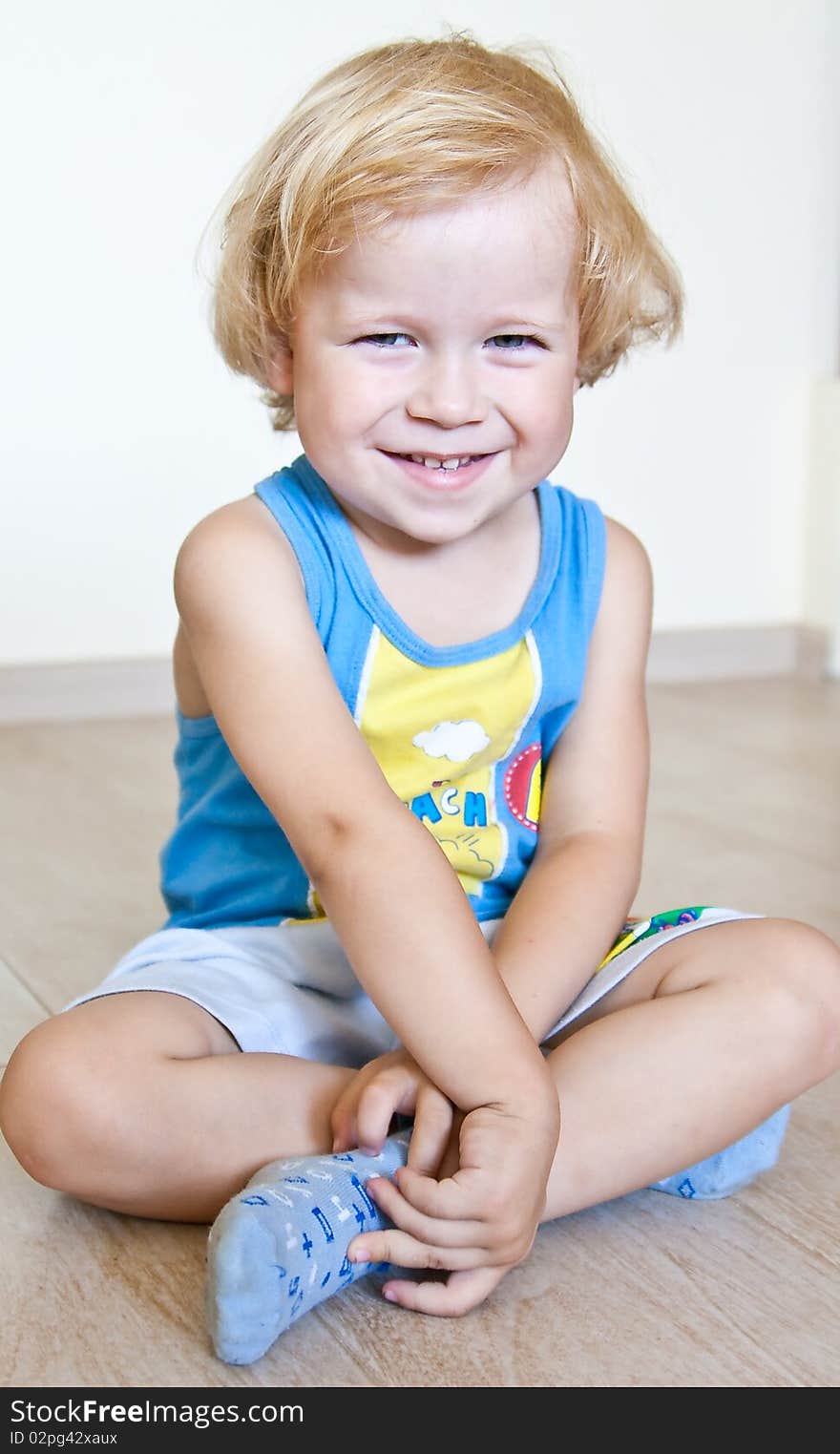 Merry kid with sparkling eyes, happy look, sitting at home on the floor. Merry kid with sparkling eyes, happy look, sitting at home on the floor