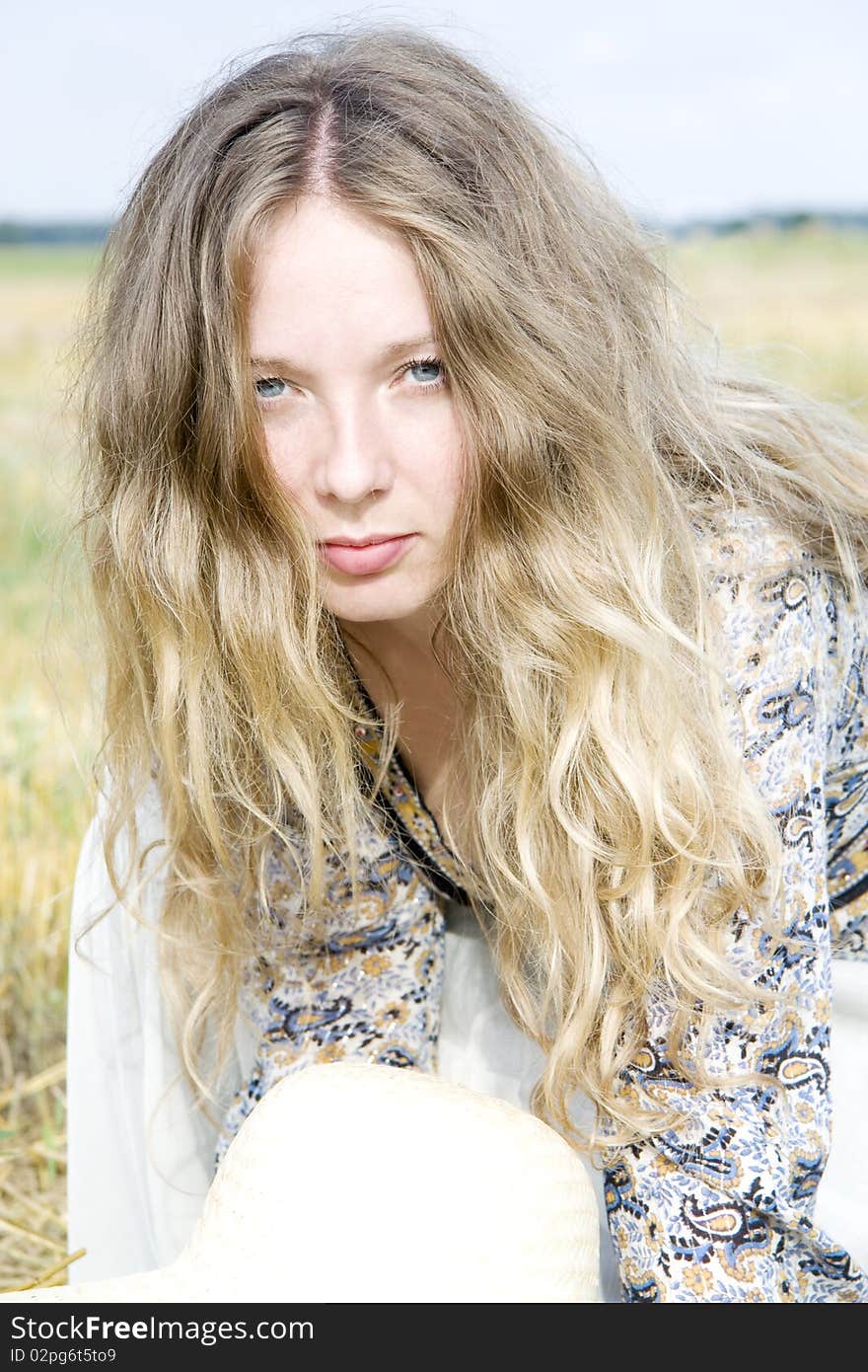 The woman with magnificent hair with a sight of a lioness looks at the victim against the blue sky. The woman with magnificent hair with a sight of a lioness looks at the victim against the blue sky