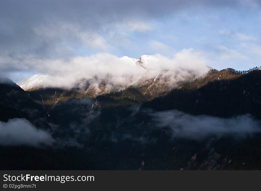 Mountain landscape with green trees covered and white cloudscape