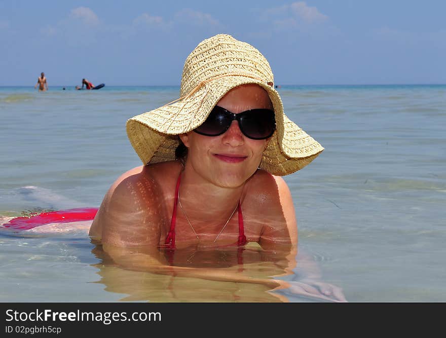 Girl with straw hat in sea