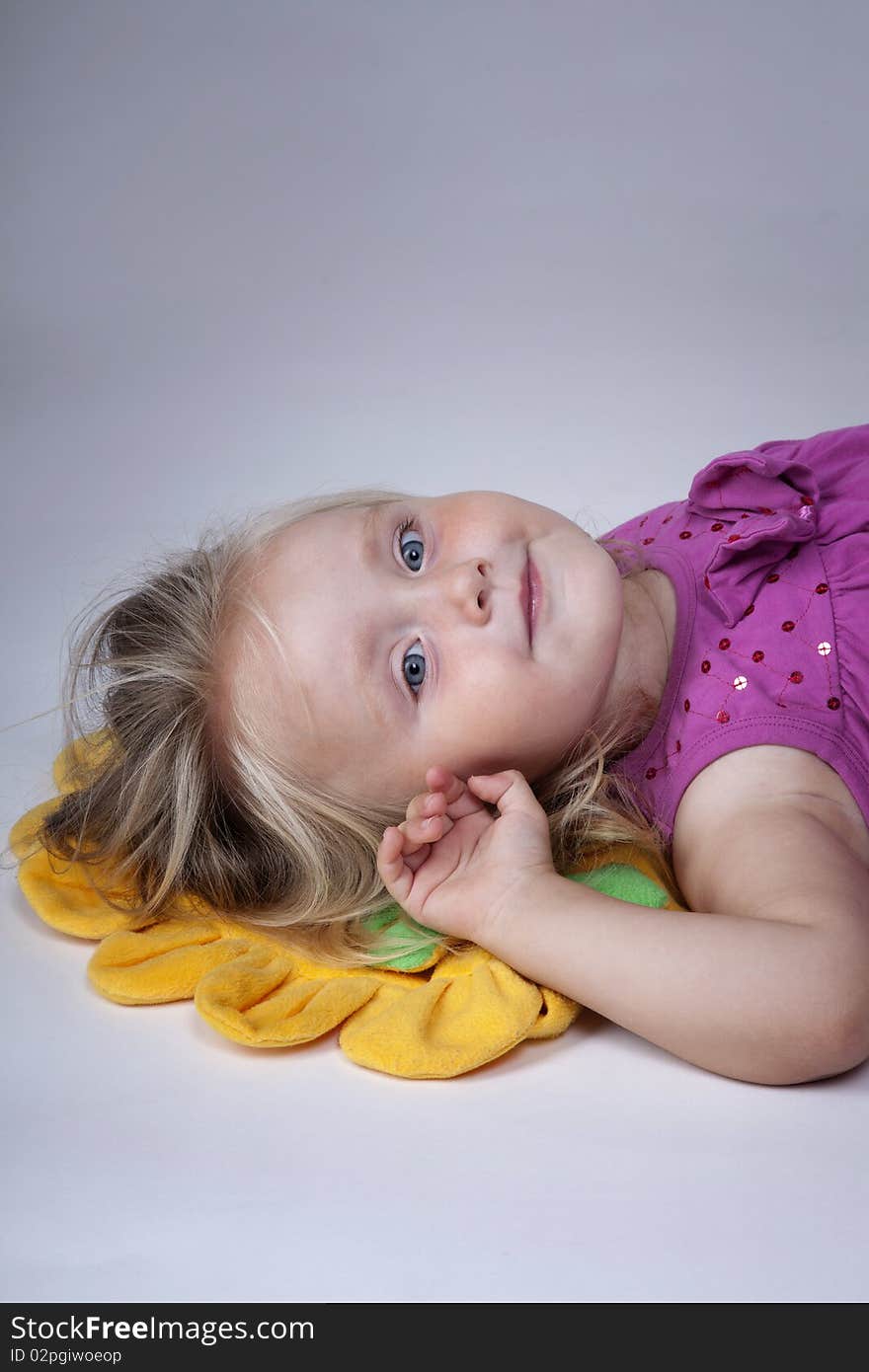 Little girl with her head on a yellow pillow. Little girl with her head on a yellow pillow