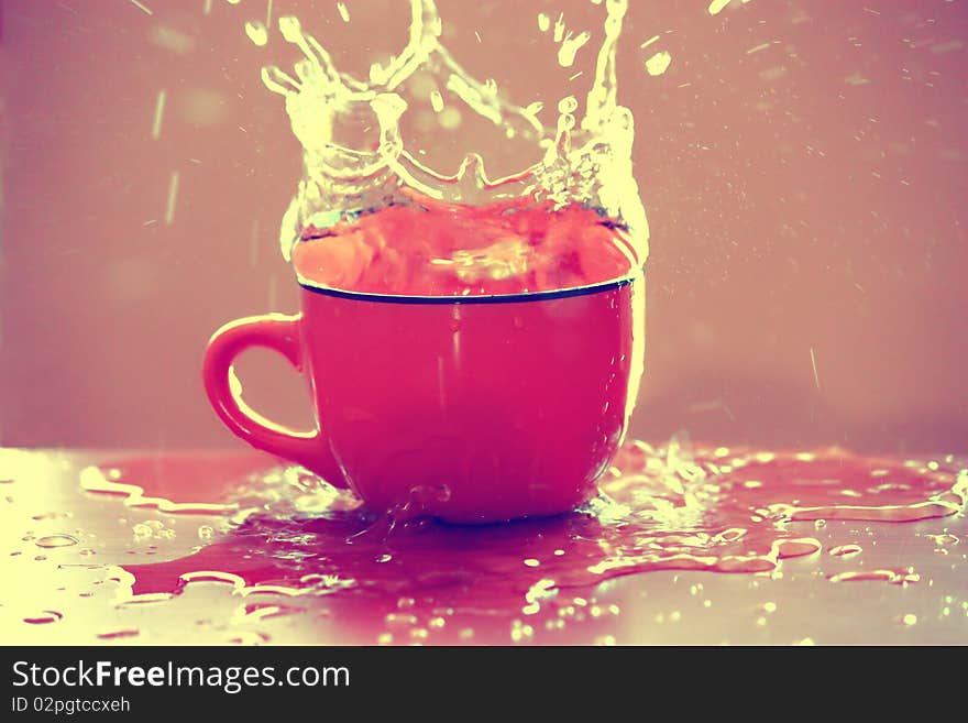 Water splashing from a pink cup. Water splashing from a pink cup