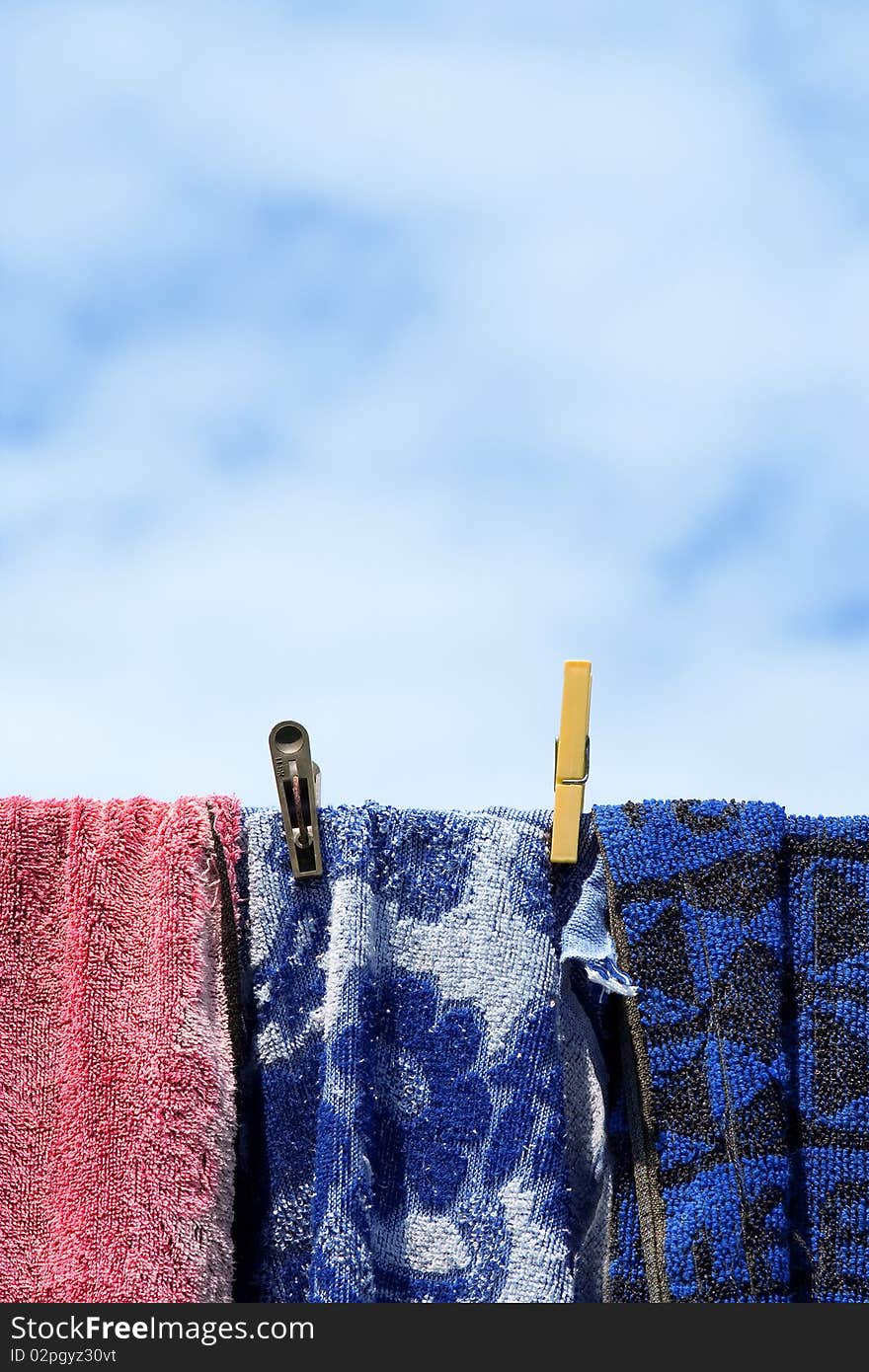 Drying in the street colored towels against the sky