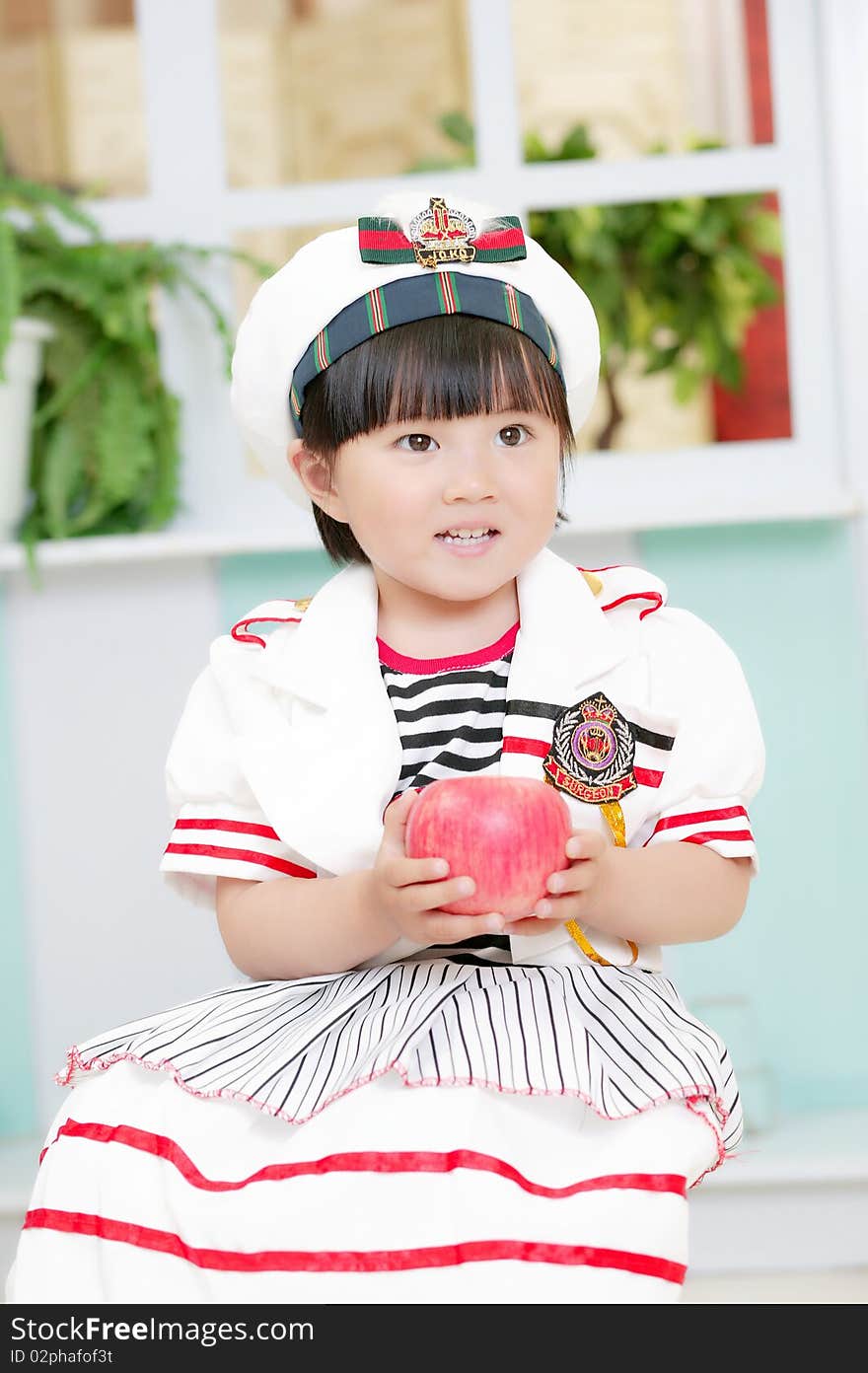 Cute baby girl with a red apple